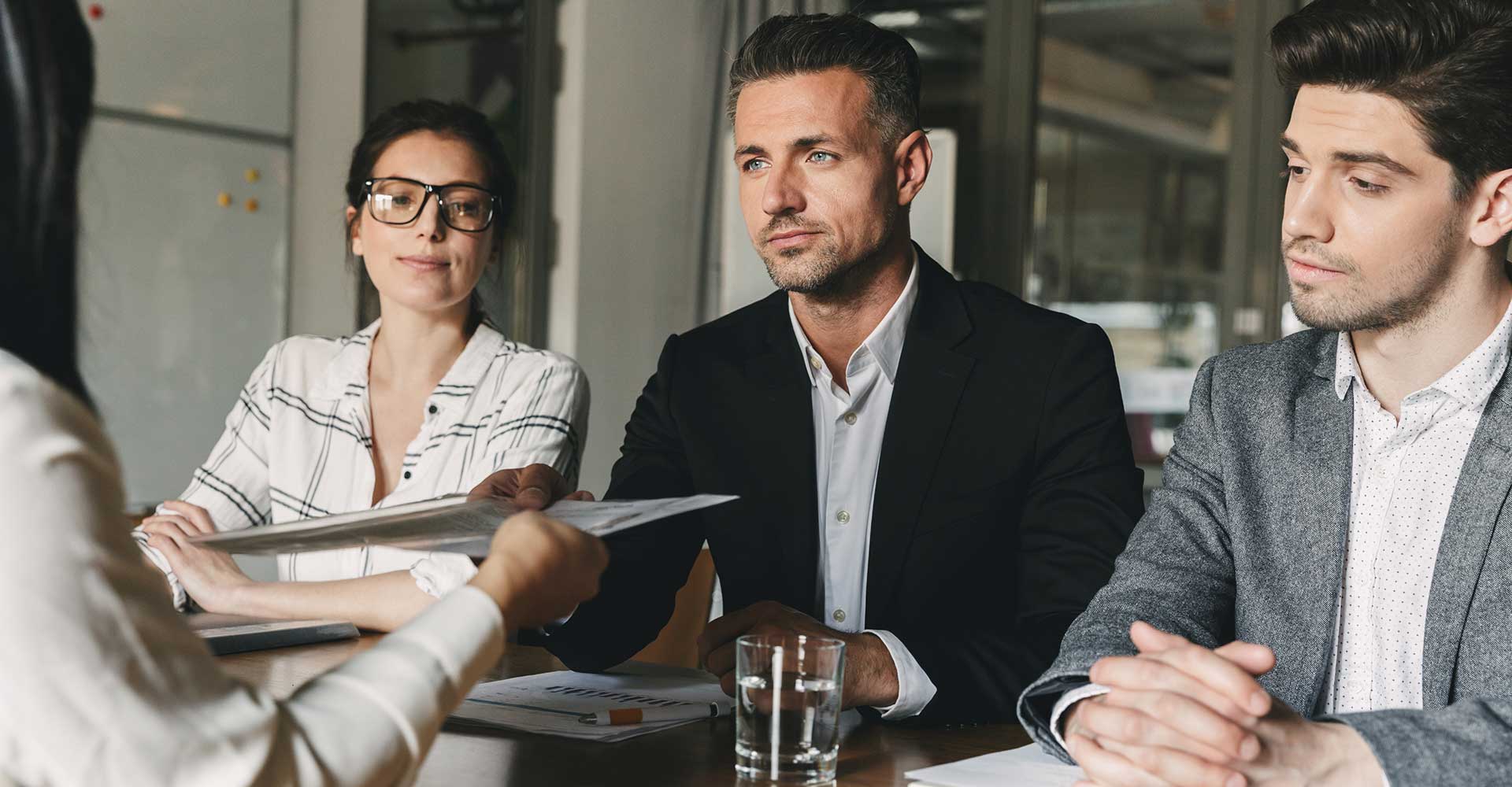 Three professionals in business attire seated at a table